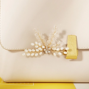 Macro shot of luxury pearl and rhinestone shoe clip on a beige leather bag