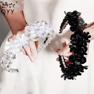 Detailed view of handmade beaded floral headbands with crystals and pearls in black and white