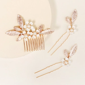 Detail of rose gold bridal hair comb set with white matte flowers and pearls