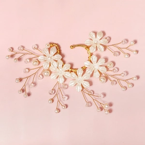 Detailed view of handmade bridal ear cuff with white flowers, pearls and crystal beads