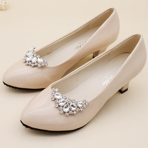 Close-up of sparkling rhinestone fan decorations on elegant beige pointed cat heel shoes