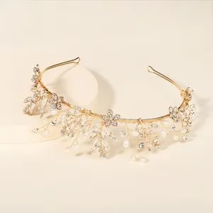 Close-up of golden bridal headband with crystals, pearls and metal floral details