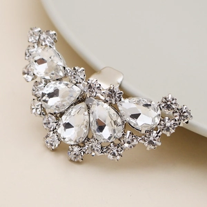 Macro shot of sparkling pear-shaped rhinestone shoe clips with silver alloy base detailing