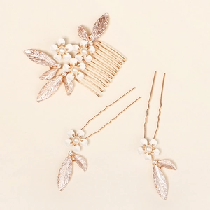 Detailed macro view of three rose gold pearl flower hair pins and comb wedding set