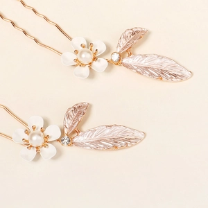 Detailed close-up of handmade pearl flower hair pins with rose gold leaves and zircons