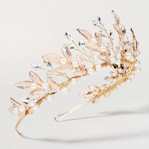 Detail of handmade bridal headband with gold wires, white pearls and crystal leaves