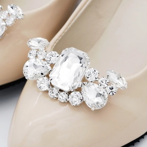 Macro shot of detachable sparkling rhinestone buckle on elegant almond pointed bridal shoe