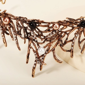 Detailopname van vintage bronzen bruidskroon met zwarte parels en kristallen elementen
