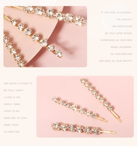 Detailed macro view of gold-tone metal hairpins with shimmering crystal rhinestones