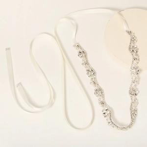 Close-up of bridal belt with rhinestones and faux pearls on ivory satin ribbon