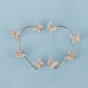 Detail of butterfly ear cuffs with gold plating and white rhinestones in heart arrangement