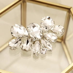 Macro detail of rhinestone shoe clips with diverse crystal cuts on a golden tray