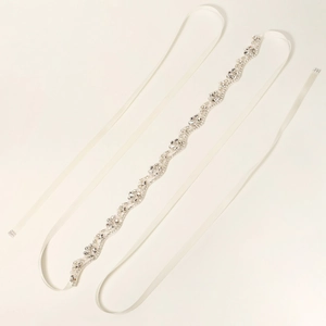 Detailed macro view of wedding sash belt with sparkling rhinestones and pearls on satin