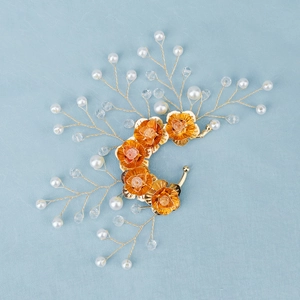 Detailed close-up of handmade gold floral ear cuff with pearls and crystals