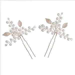 Detail of rose gold bridal hair pins with white pearls, crystals and metal leaves