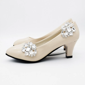 Detailed view of sparkling geometric silver rhinestone clip on beige pointed stiletto shoe