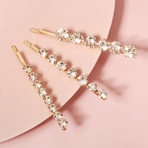 Three-piece set of elegant gold metal hair clips featuring sparkling rhinestones and floral detail