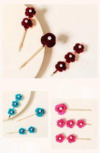 Detail of velvet rose hair clips with pearls on gold-toned metal barrettes