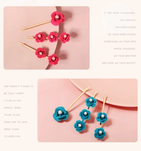 Detail of floral hair clips set with fabric roses, imitation pearls and gold metal base
