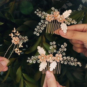 Close-up of bridal rose gold hair comb set with pink flowers and crystal beads