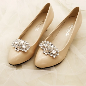 Detailed close-up of sparkling rhinestone flower clips on elegant beige stiletto heels