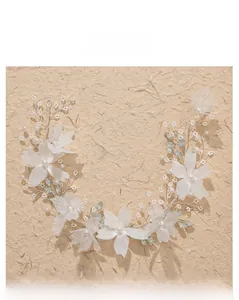Detail of handcrafted bridal headband with fabric flowers and white pearls on silver wire