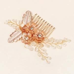 Detailed view of handmade crystal flower hair comb with pink petals and gold leaves