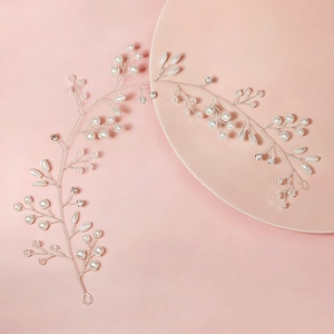 Elegant bridal vine headband with silver wire, white pearls, and crystals on a pink surface