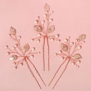 Detail of rose gold bridal hair pins with beaded leaves and white pearls for wedding