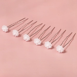 Close-up of 6-piece U-shaped hair pins with delicate white resin flowers on silver wire