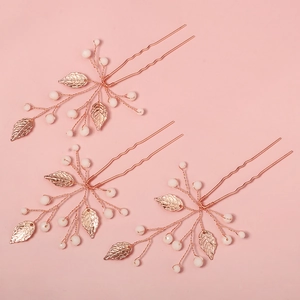 Detail of three handmade rose gold hair pins with beads and metal leaves for bridal hairstyles