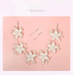Détail d'un serre-tête mariée fait main avec fleurs en acrylique et perles sur fond rose