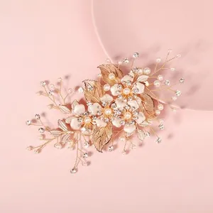 Detail of floral champagne gold hairclip with white petals, pearls and crystals