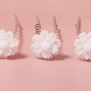 Three elegant white flower hair pins for wedding and party hairstyles on pink background