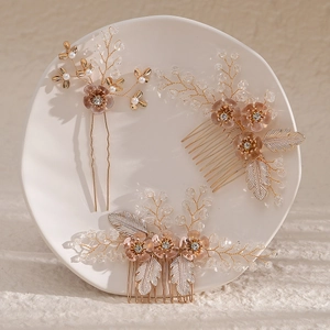 Handmade bridal hair comb set with crystal flowers and pearls on a white plate