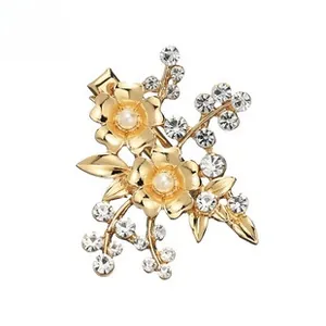 Close-up of golden floral hair clip with white pearls and sparkling rhinestones