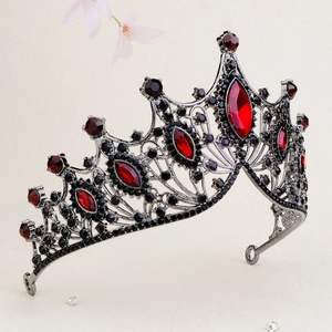 Macro view of baroque bridal crown with red gemstones and black rhinestones on dark metal