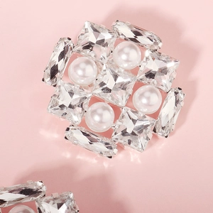 Detail of a round crystal shoe clip with sparkling rhinestones and white pearls