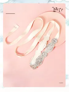 Gros plan d'une ceinture de mariée avec strass scintillants sur un ruban de satin