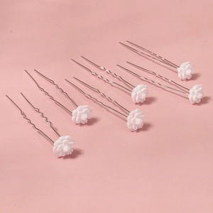 Detail of 6-piece bridal hair pins featuring delicate white flowers on silver wavy U-pins