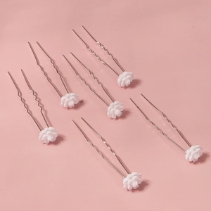 Detail view of 6-piece white floral bridal hair pins with silver wavy U-shaped metal stems