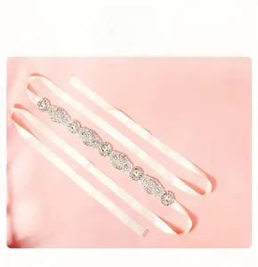 Détail de la ceinture de mariée en strass avec motifs floraux sur ruban de satin ivoire