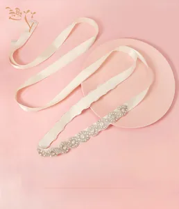 Detailed close-up of hand-sewn silver rhinestone crystal bridal belt on ivory ribbon