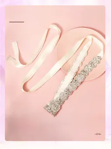 Close-up of elegant crystal bridal belt with silver claw chain on a pink satin ribbon