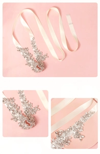 Macro detail of bridal wedding belt showing crystal floral rhinestones on ivory satin ribbon