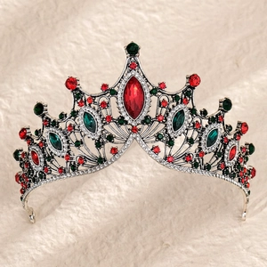 Detailed macro view of baroque crown with emerald and ruby rhinestones on faux fur