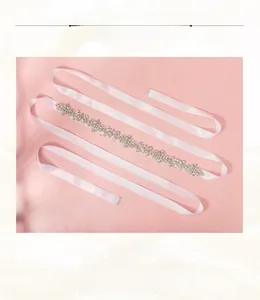 Détail de la ceinture de mariée en satin blanc ornée de cristaux et strass de luxe
