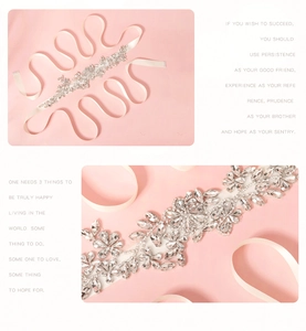 Macro detail of bridal belt featuring crystal leaf patterns on off-white silk ribbon