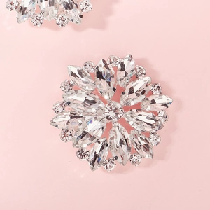 Detailed macro view of a silver floral rhinestone shoe clip on a soft pink background