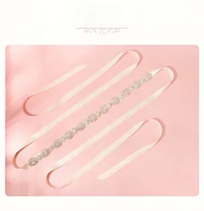 Détail de ceinture de mariée avec strass et perles sur ruban de satin champagne pour robe de bal